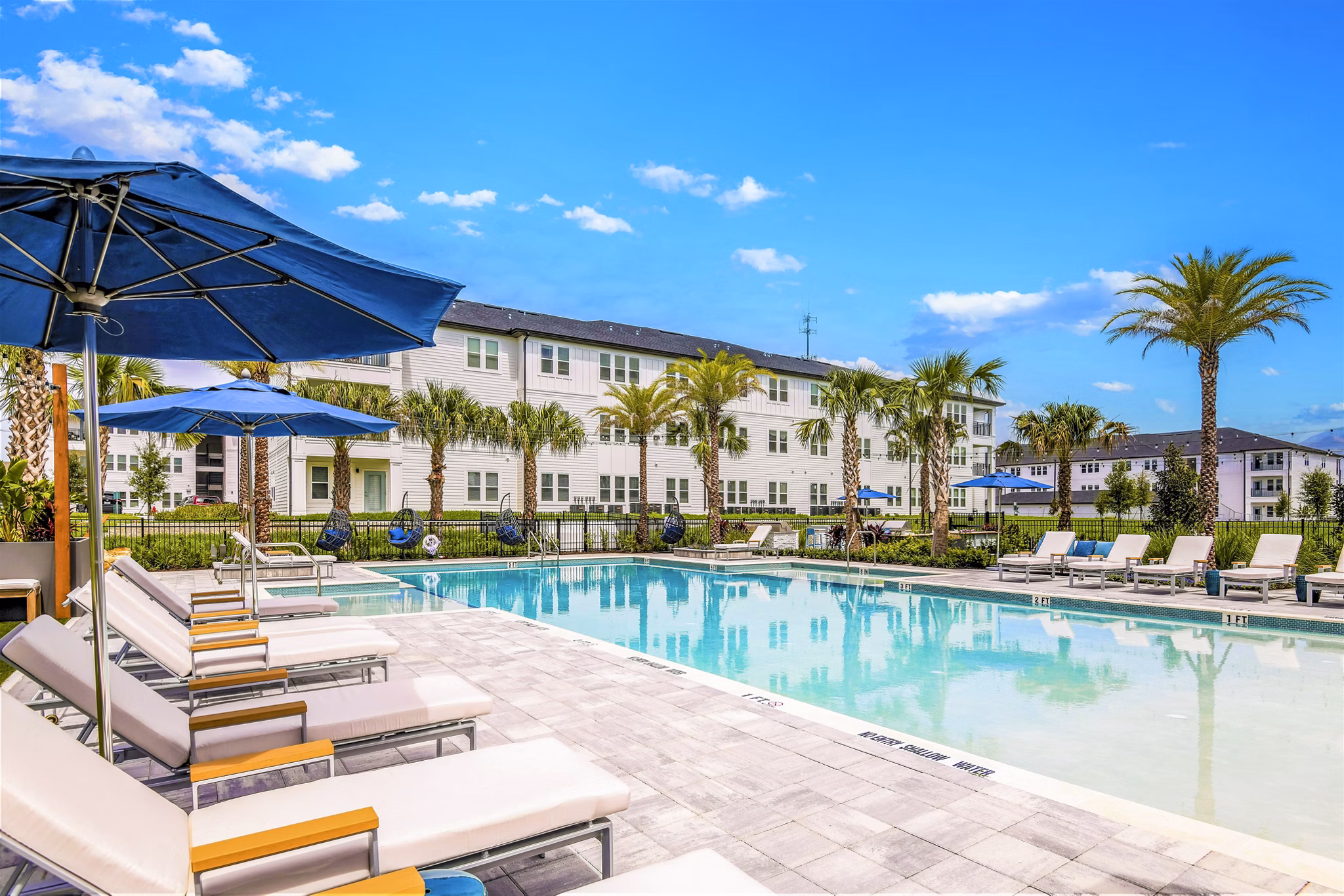 Resort-style pool with lounge seating at Greystar's Ltd Champions Ridge Apartments