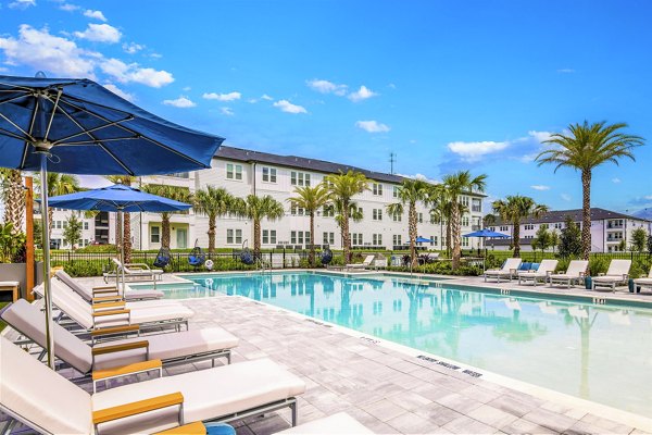 Resort-style pool with lounge seating at Greystar's Ltd Champions Ridge Apartments