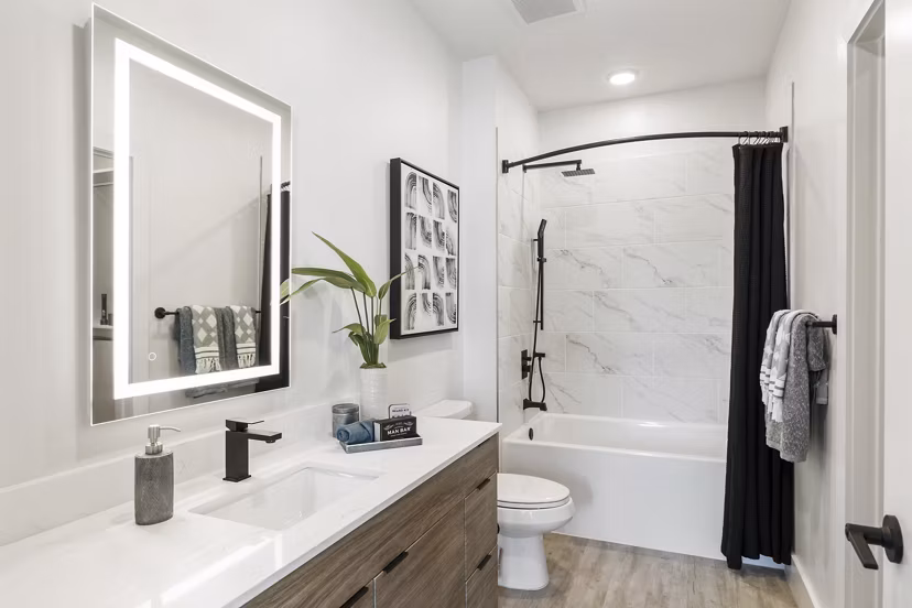 Modern bathroom with stylish fixtures and large mirror at Elev8 Apartments
