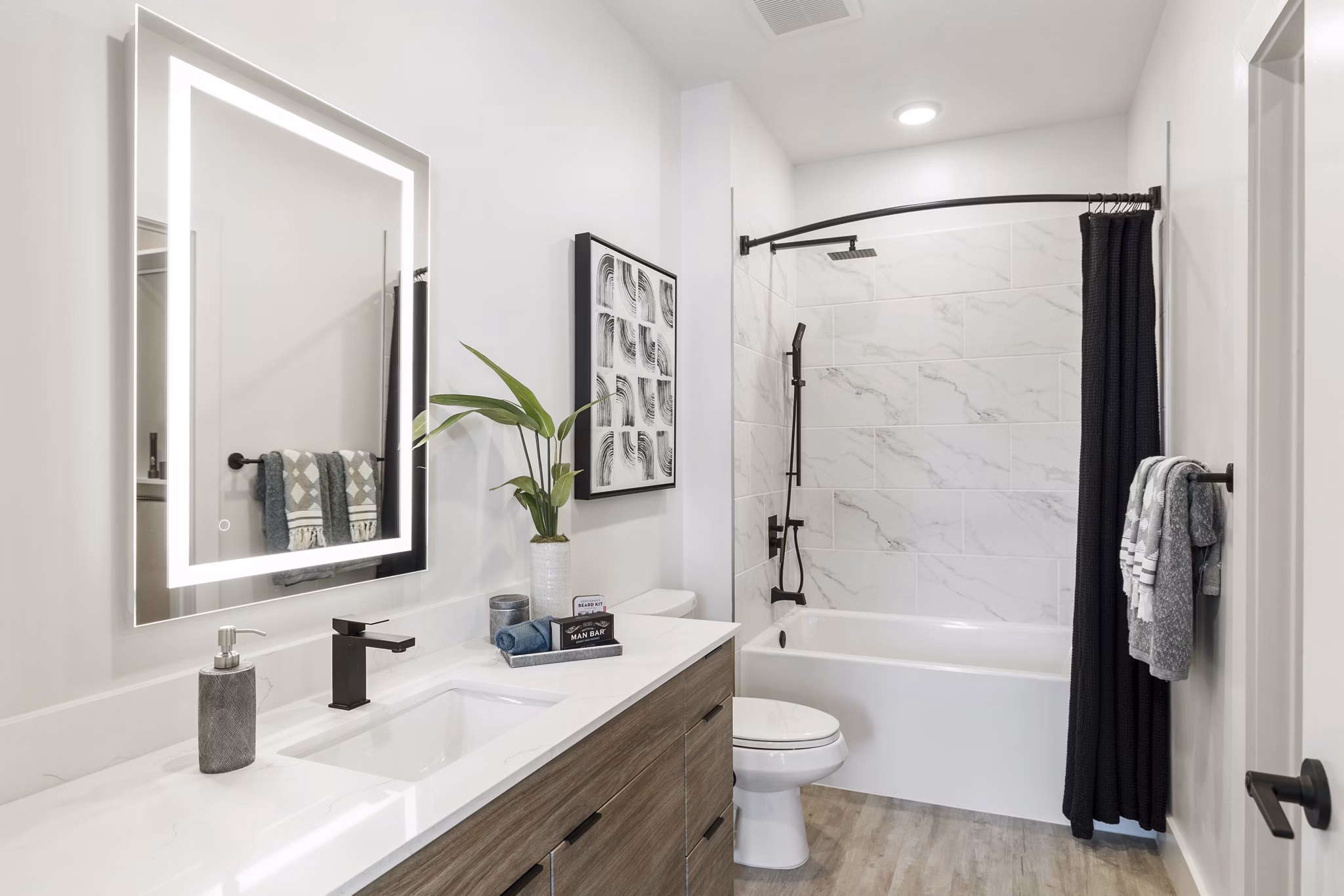 Modern bathroom with stylish fixtures and large mirror at Elev8 Apartments