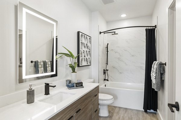Modern bathroom with stylish fixtures and large mirror at Elev8 Apartments