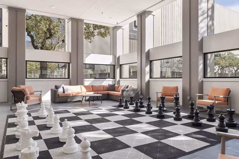 Game room with pool tables and modern lighting at Elev8 Apartments