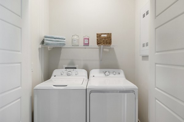 Laundry room with modern appliances in Elev8 Apartments, luxury living by Greystar