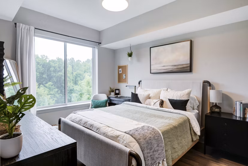 Bedroom featuring plush bedding and modern decor at Vista Fairfax Corner Apartments