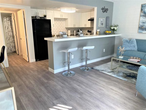 Dining area with modern furnishings in Seventh Apartments featuring large windows and elegant lighting fixtures