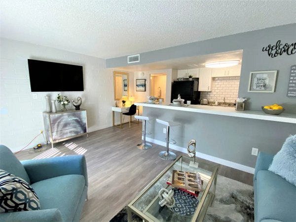 Contemporary living room with chic decor and ample natural light at Seventh Apartments, featuring urban luxury and comfort
