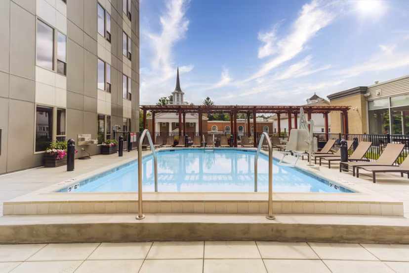 Resort-style pool at DASH Downers Grove Apartments featuring comfortable lounge chairs