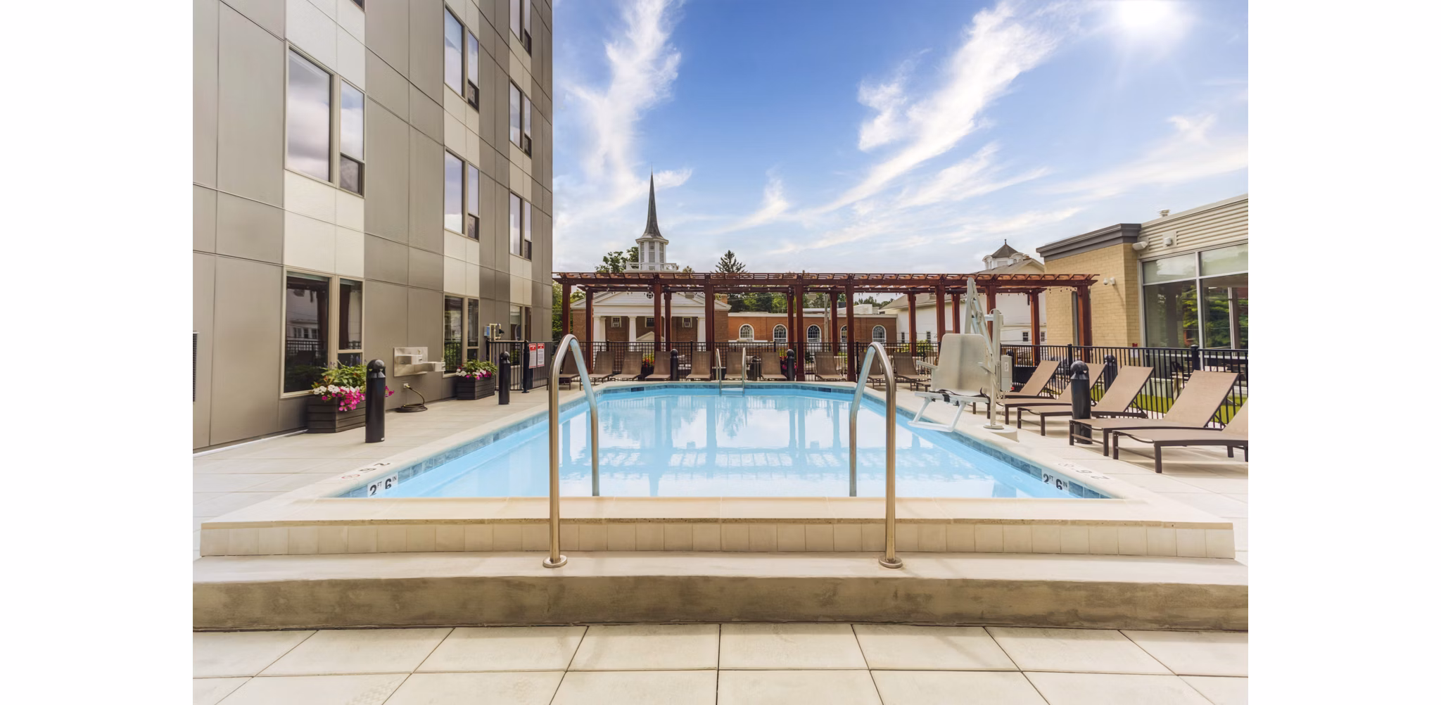 Resort-style pool at DASH Downers Grove Apartments featuring comfortable lounge chairs