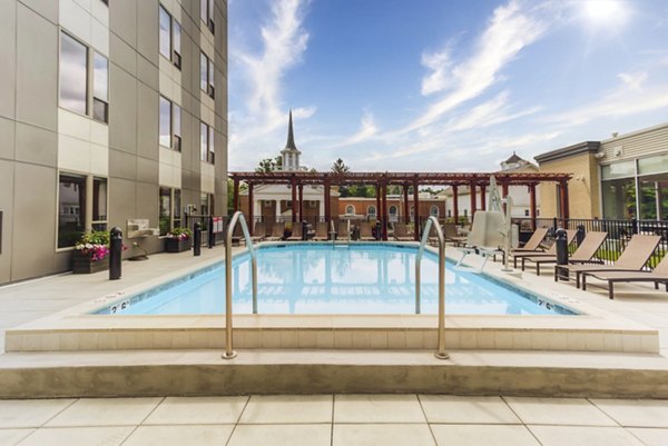 Resort-style pool at DASH Downers Grove Apartments featuring comfortable lounge chairs