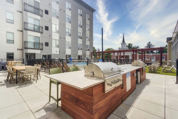 Outdoor grill area with modern seating at DASH Downers Grove Apartments, perfect for social gatherings and summer cookouts