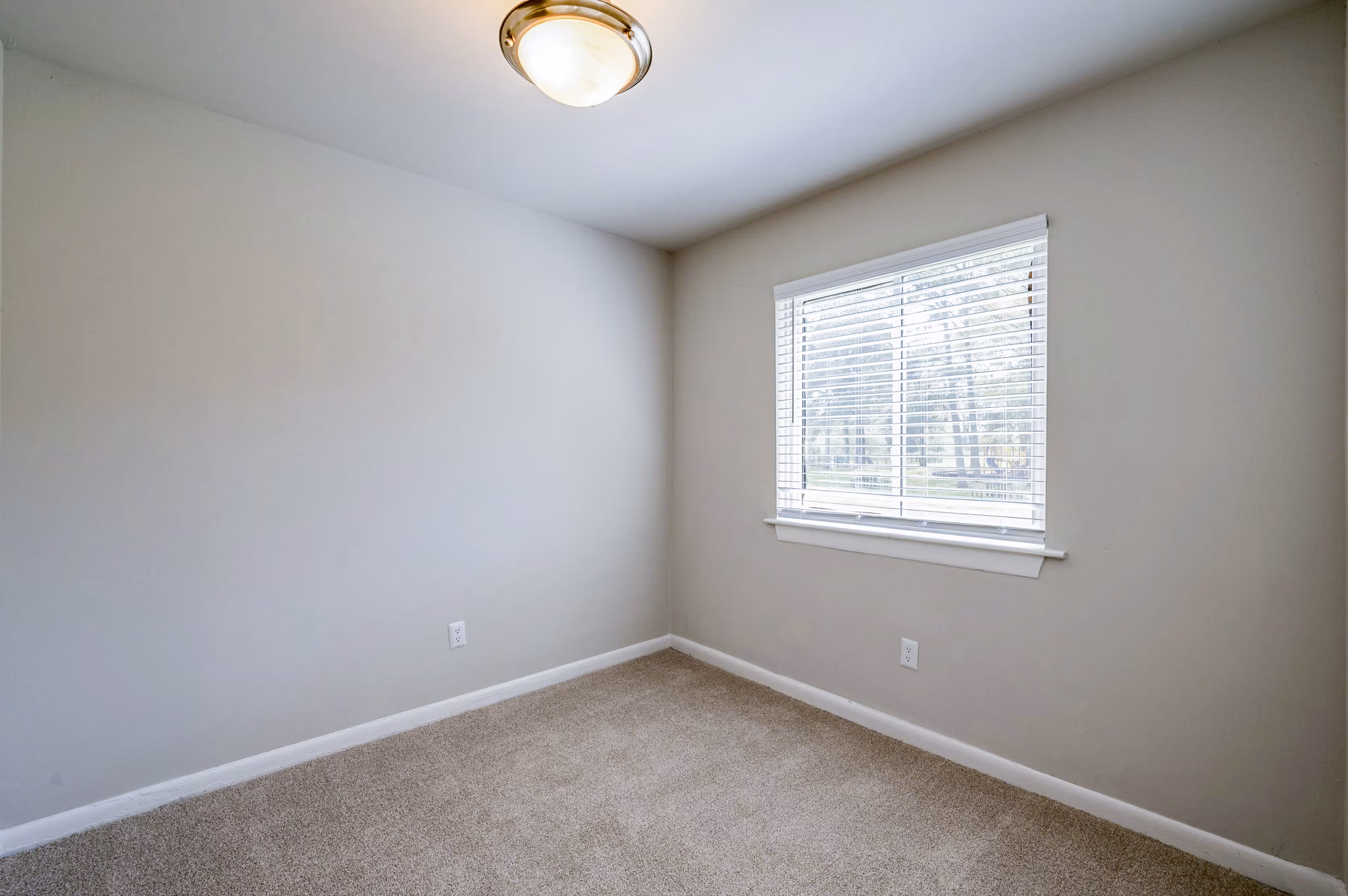 Woodshire Apartments: Cozy bedroom with modern furnishings and large window in this luxury community