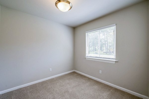 Woodshire Apartments: Cozy bedroom with modern furnishings and large window in this luxury community