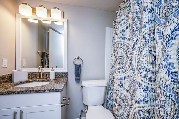 Cozy bedroom featuring elegant decor and ample natural light in Woodshire Apartments
