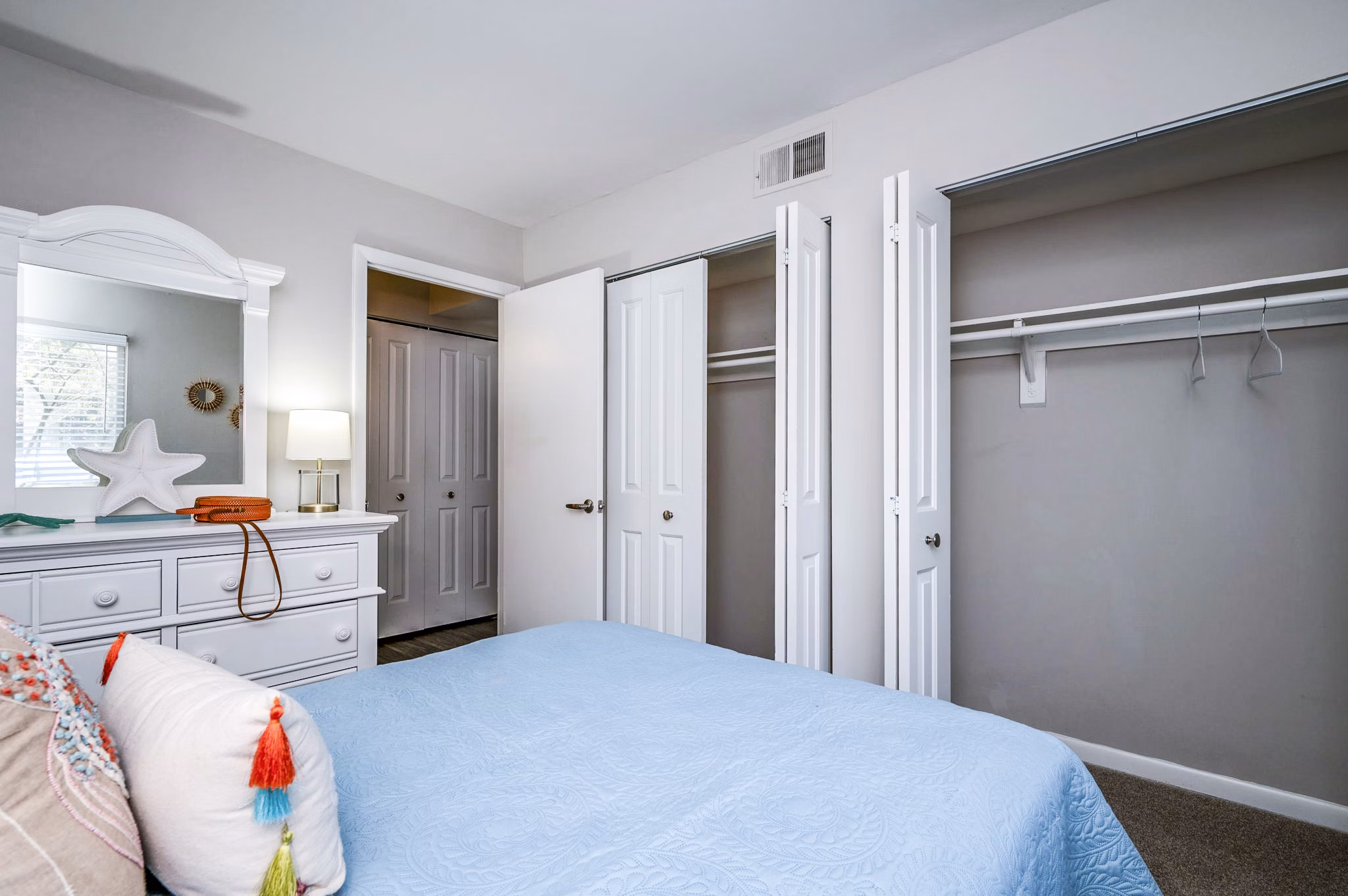 Cozy bedroom with modern decor at Woodshire Apartments featuring luxury finishes