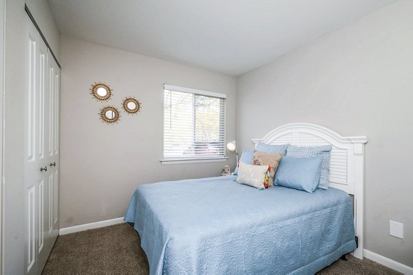 Woodshire Apartments: Cozy bedroom with stylish decor and natural light