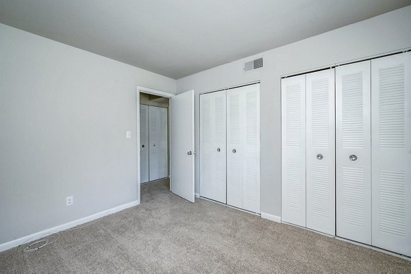 Cozy bedroom featuring modern decor and large windows in Woodshire Apartments