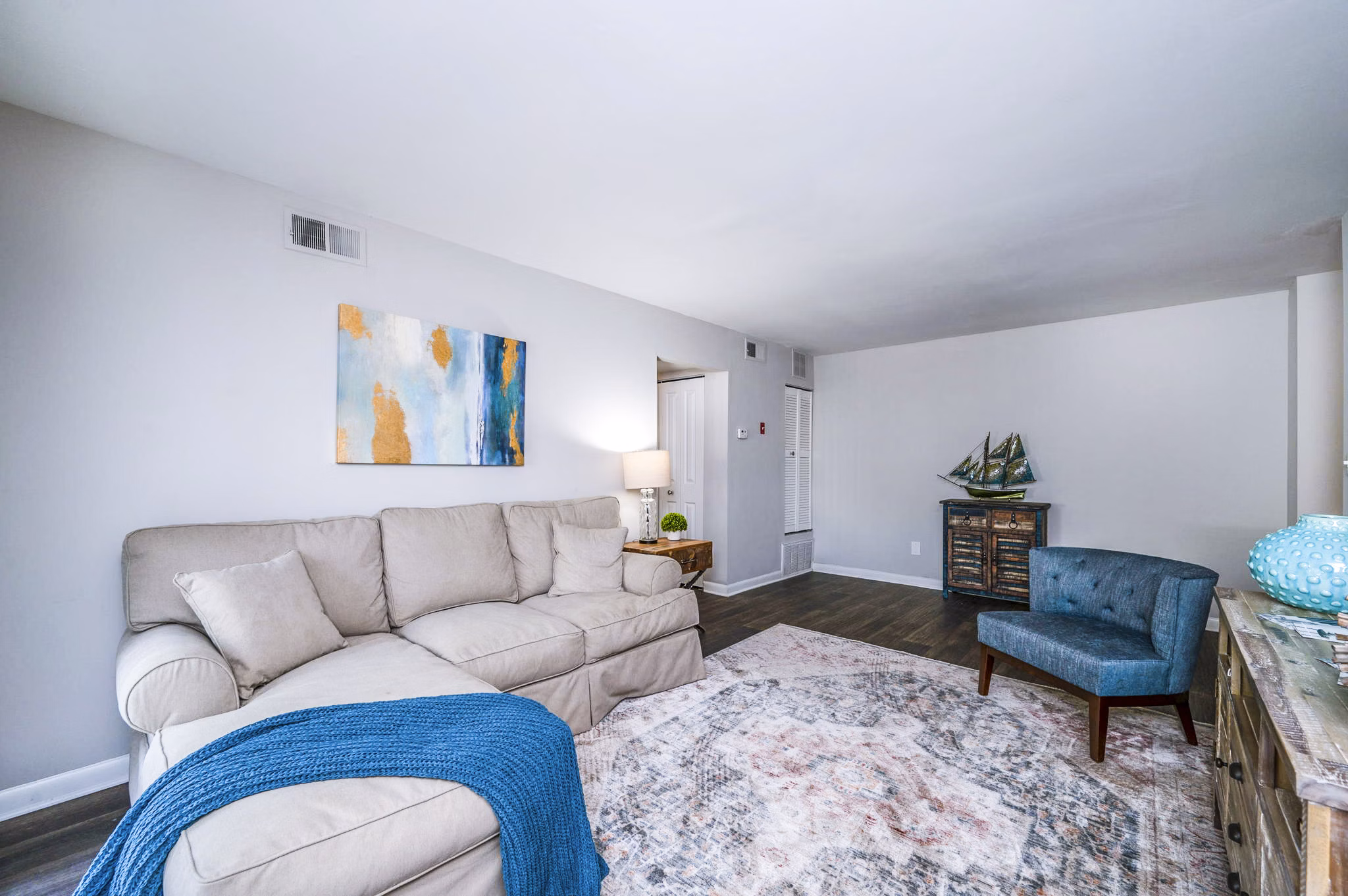 Open living room with contemporary decor and natural light at Woodshire Apartments