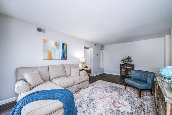 Open living room with contemporary decor and natural light at Woodshire Apartments