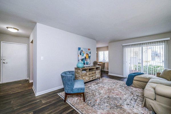 Spacious living room featuring modern furniture and large windows in Woodshire Apartments