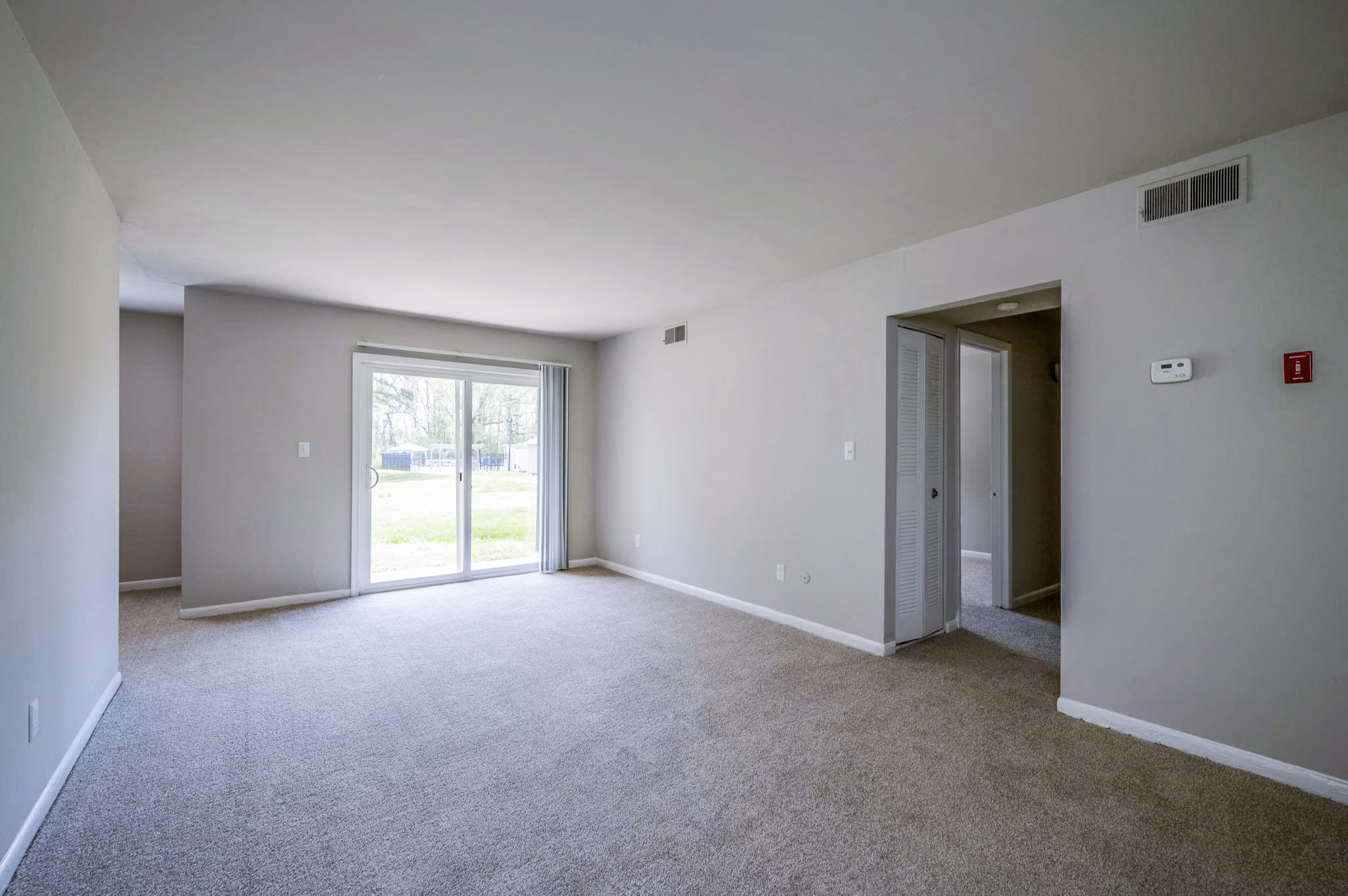 Spacious living room with modern decor at Woodshire Apartments featuring sleek furnishings and natural light