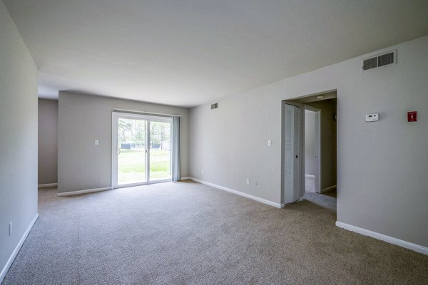 Spacious living room with modern decor at Woodshire Apartments featuring sleek furnishings and natural light