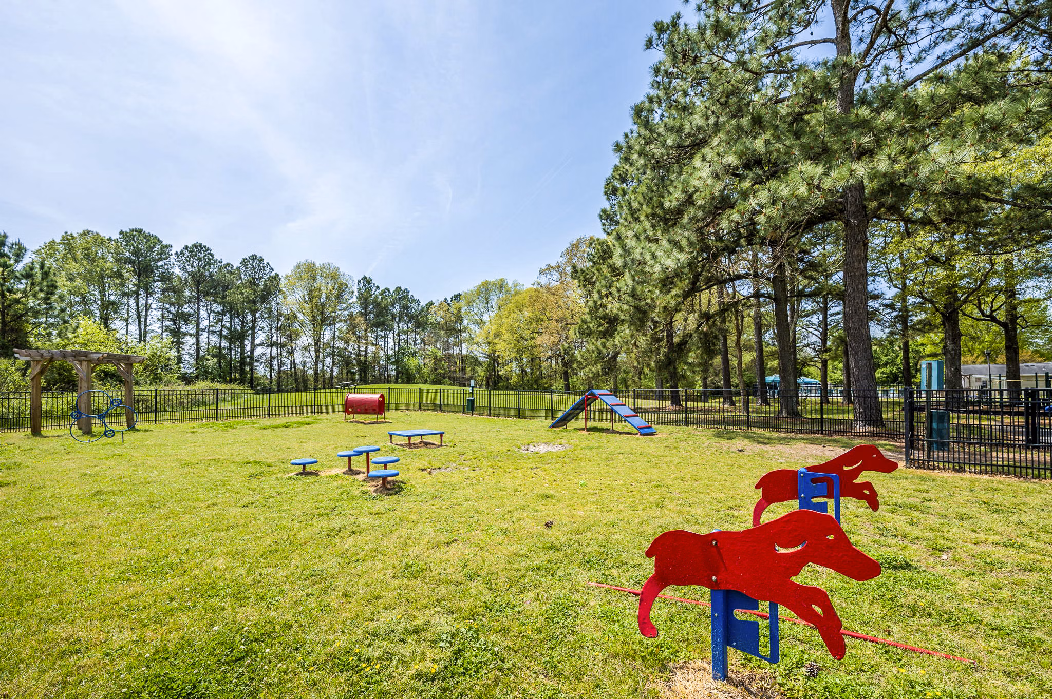 Leash-free dog park with agility equipment at Woodshire Apartments