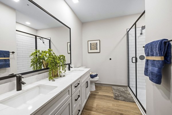 Bathroom featuring modern fixtures and marble countertops in The Artreaux Apartments