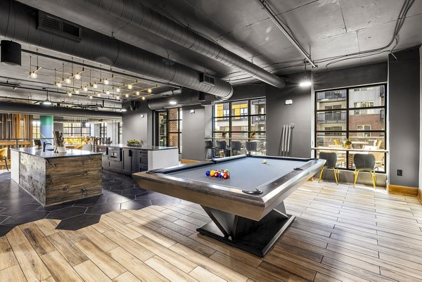 Clubhouse game room with billiards and lounge seating at The Artreaux Apartments