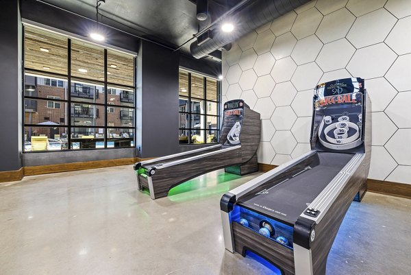 Clubhouse game room with billiards and arcade games at The Artreaux Apartments, offering luxury amenities for residents in a vibrant community