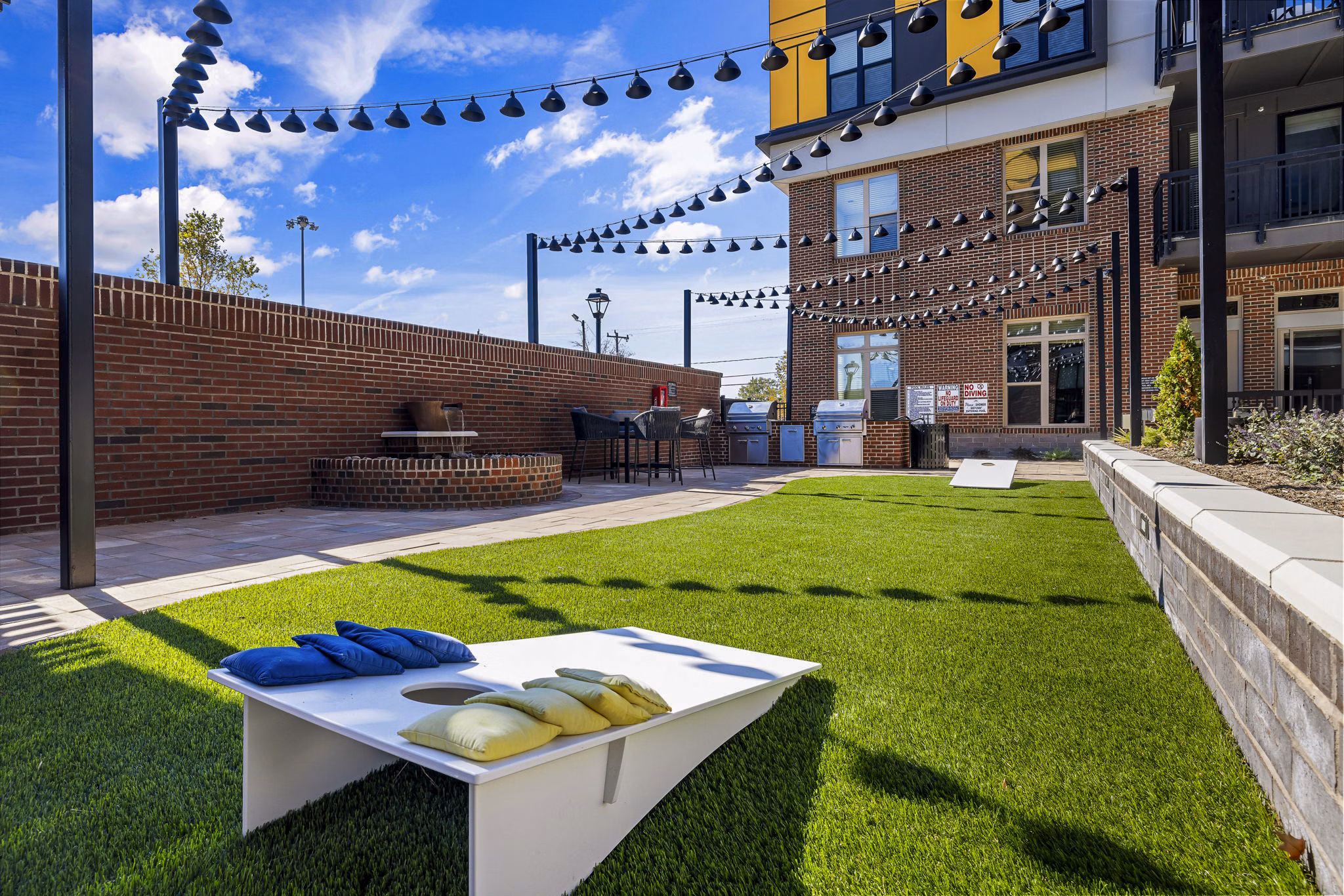 Outdoor grill and recreational area with seating at The Artreaux Apartments, offering luxury living and community spaces in a vibrant setting