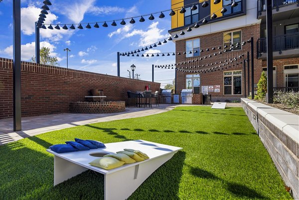Outdoor grill and recreational area with seating at The Artreaux Apartments, offering luxury living and community spaces in a vibrant setting