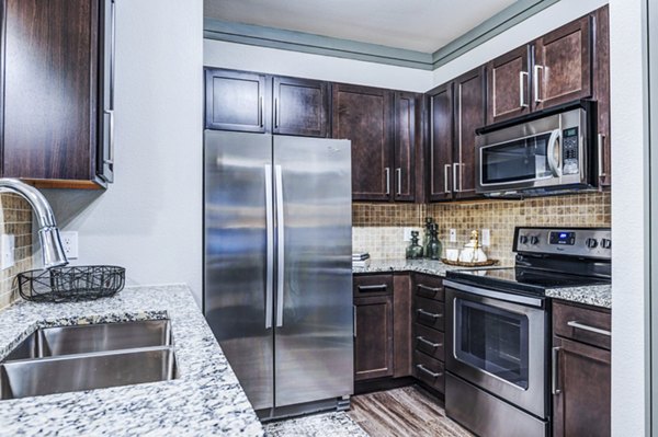 Modern kitchen with stainless steel appliances at Harlow Spring Cypress Apartments
