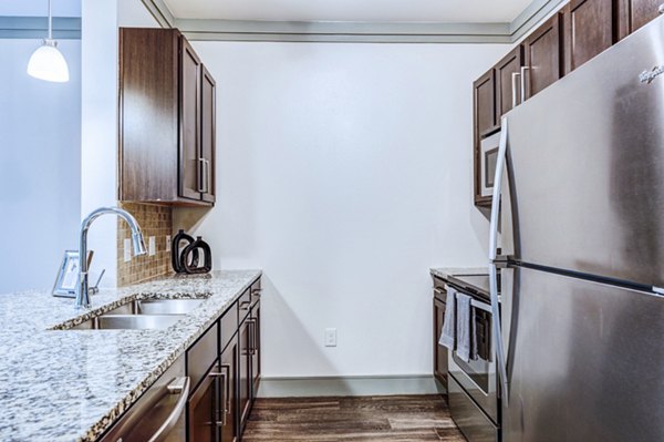 Contemporary kitchen with stainless steel appliances at Harlow Spring Cypress Apartments