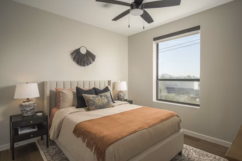 Cozy bedroom with modern decor and large windows at Smith + Rio Apartments