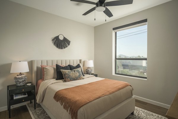 Cozy bedroom with modern decor and large windows at Smith + Rio Apartments
