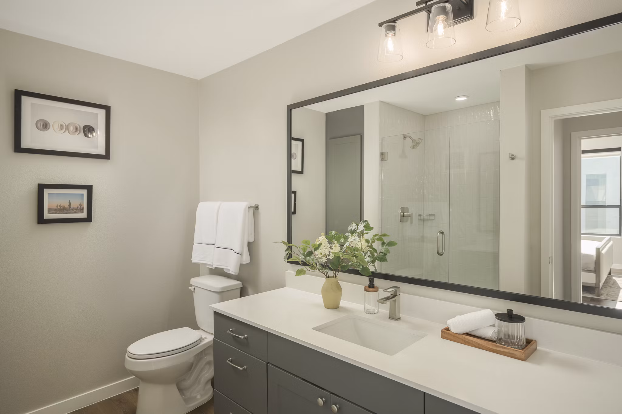 Modern bathroom with sleek fixtures and large mirror at Smith + Rio Apartments