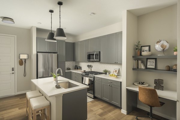 Modern kitchen with stainless steel appliances at Smith + Rio Apartments
