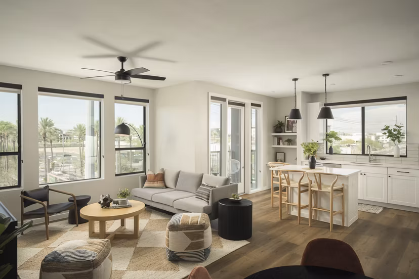 Living room featuring modern decor and large windows at Smith + Rio Apartments