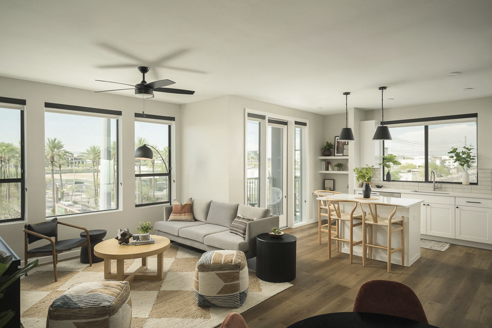 Living room featuring modern decor and large windows at Smith + Rio Apartments