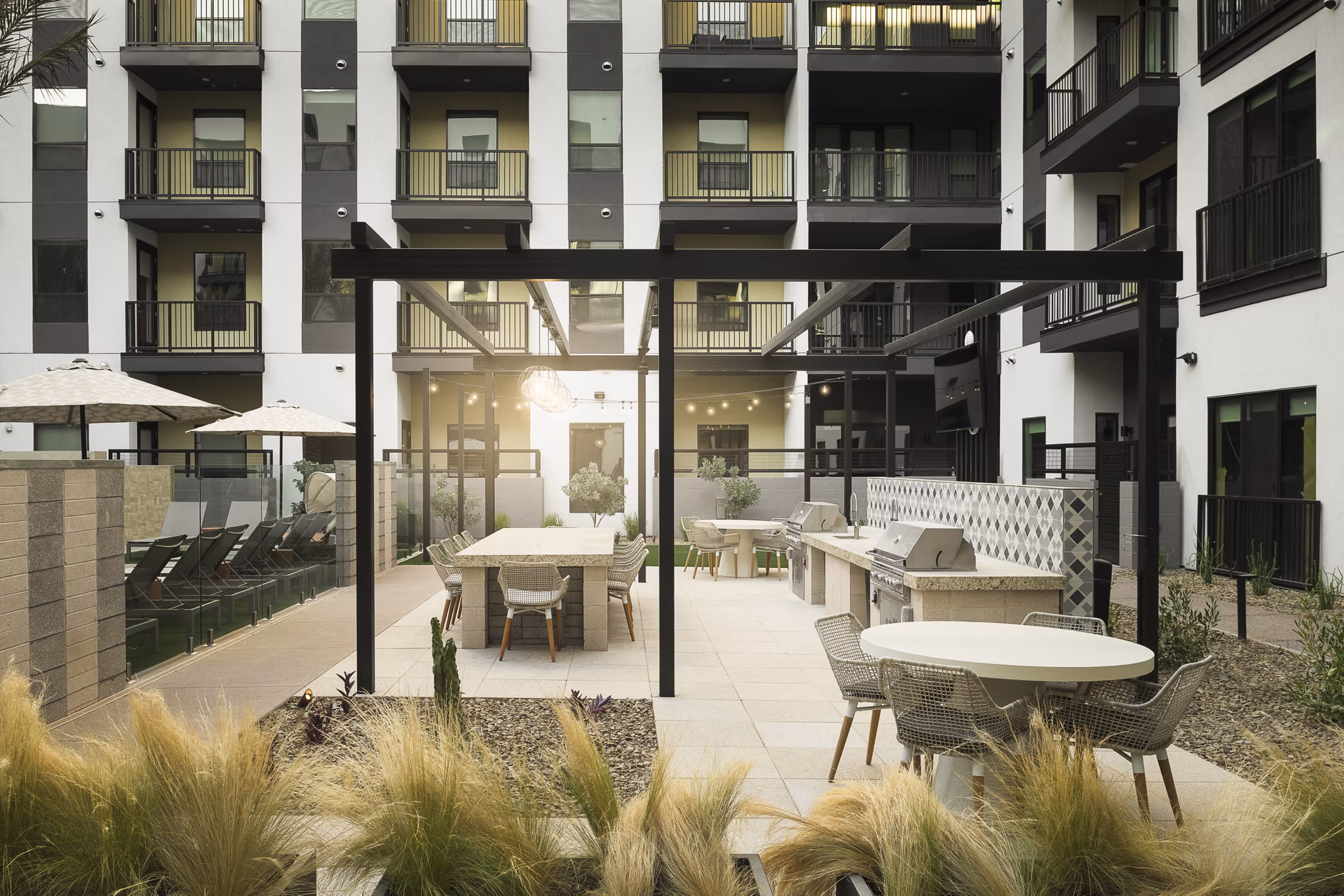 Outdoor grill area with modern furnishings at Smith + Rio Apartments