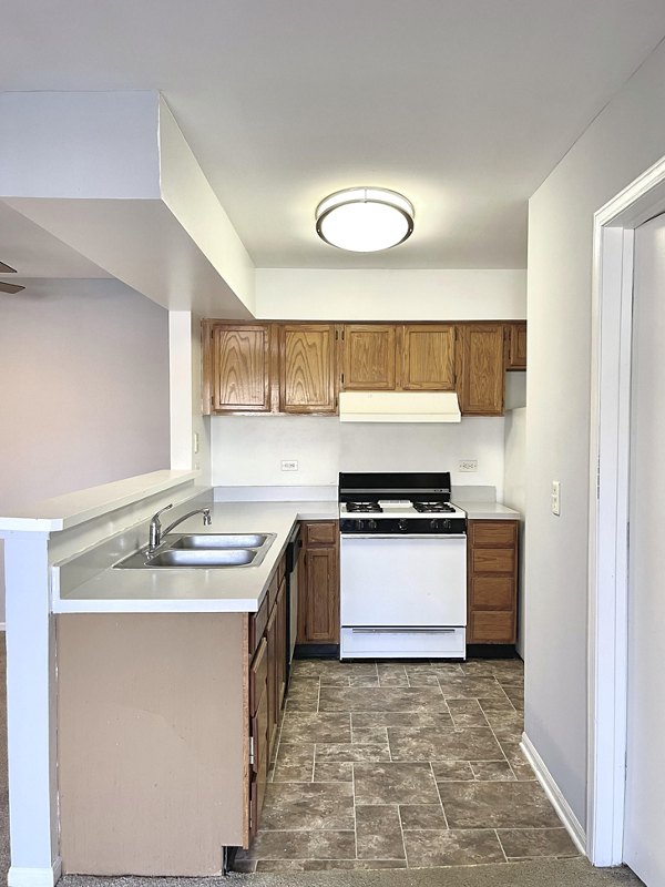 Modern kitchen with stainless steel appliances and granite countertops in Fox Pointe luxury apartments