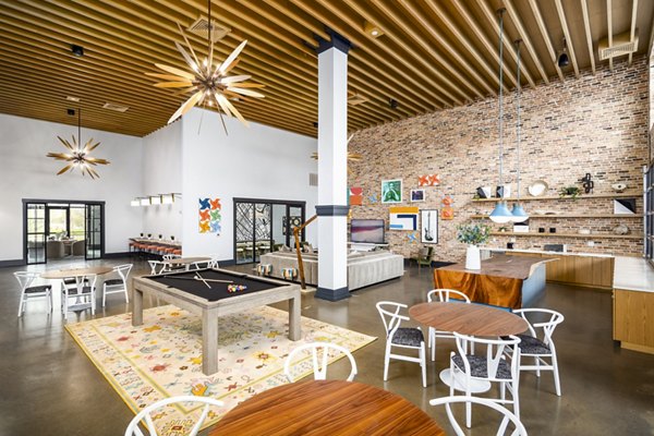 Clubhouse game room with pool table and lounge seating at Soundwater Apartments, luxury living by Greystar in a vibrant community
