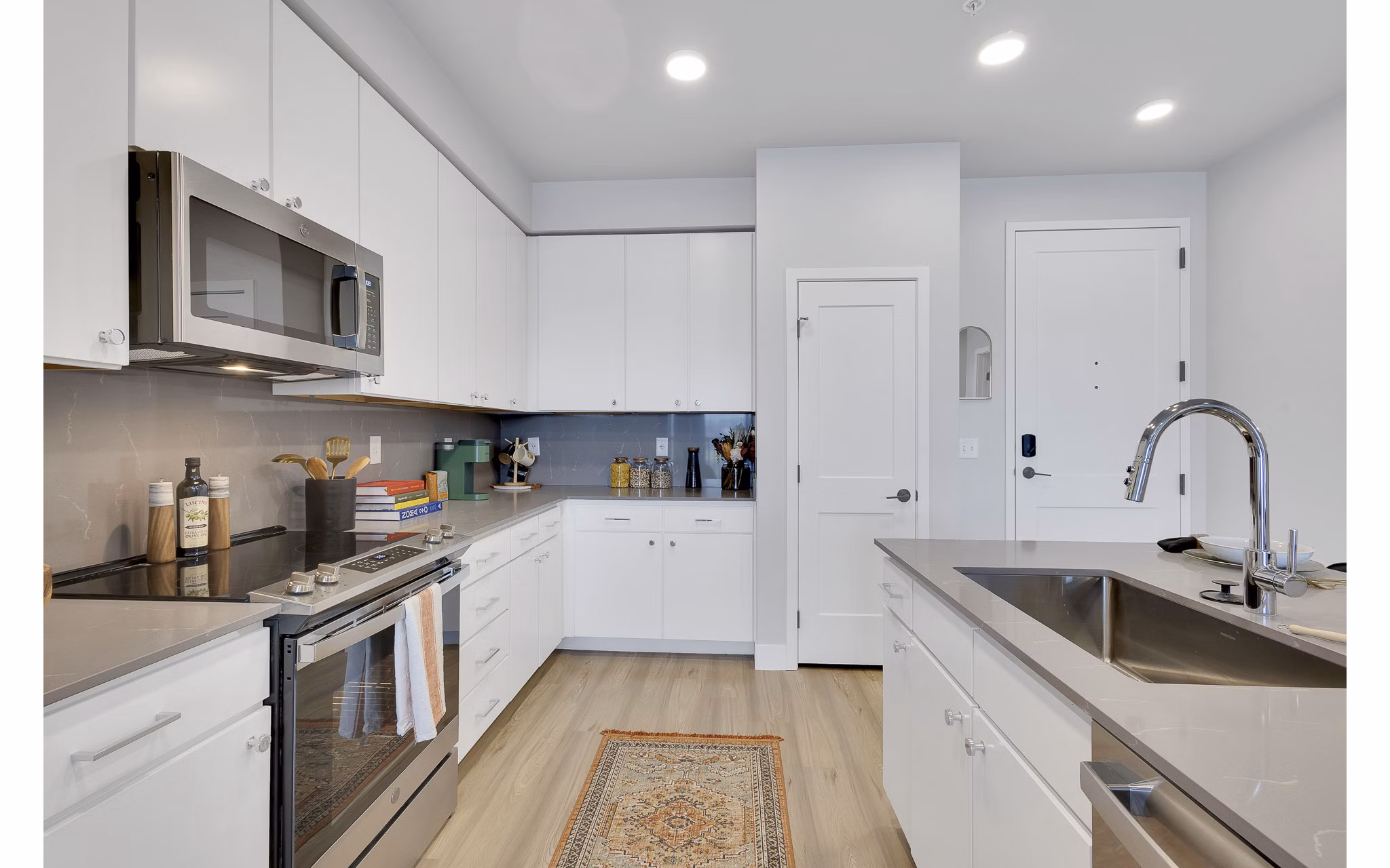 Modern kitchen with stainless steel appliances and granite countertops at The Dorsey Apartments, luxury Greystar community