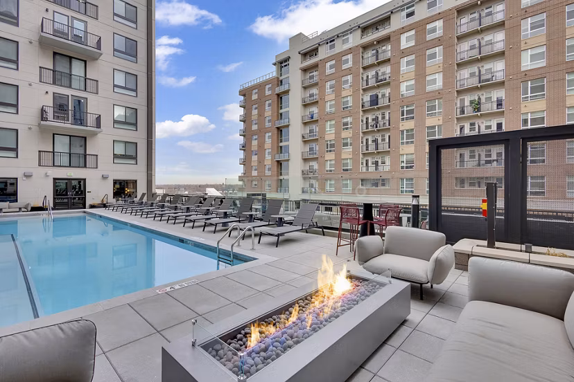 Resort-style pool at The Dorsey Apartments featuring luxurious lounge chairs and palm trees