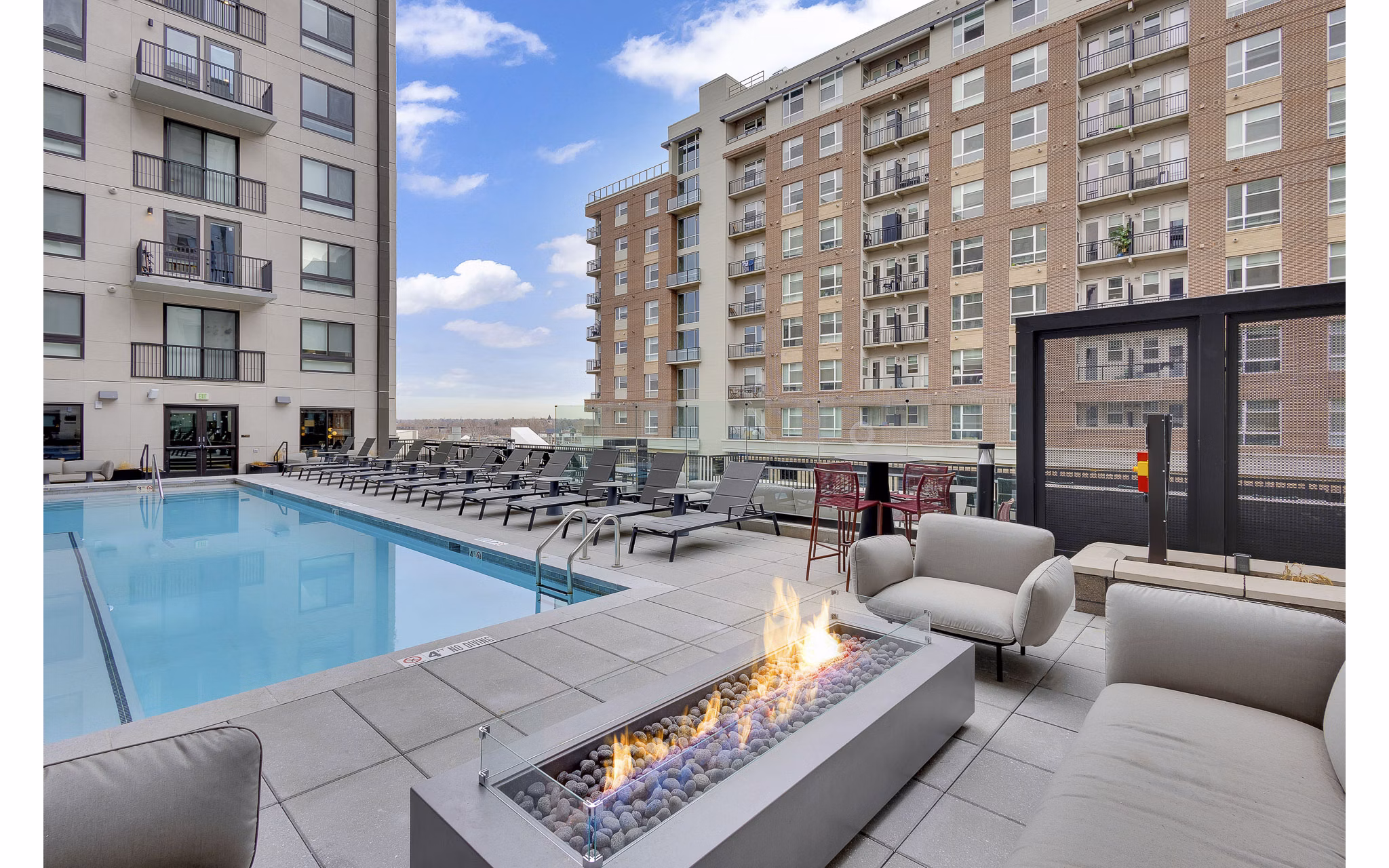 Resort-style pool at The Dorsey Apartments featuring luxurious lounge chairs and palm trees