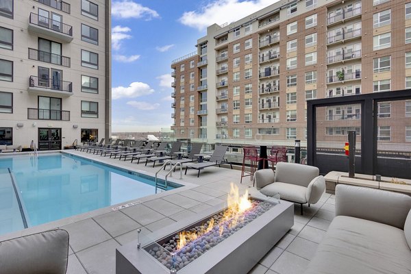 Resort-style pool at The Dorsey Apartments featuring luxurious lounge chairs and palm trees