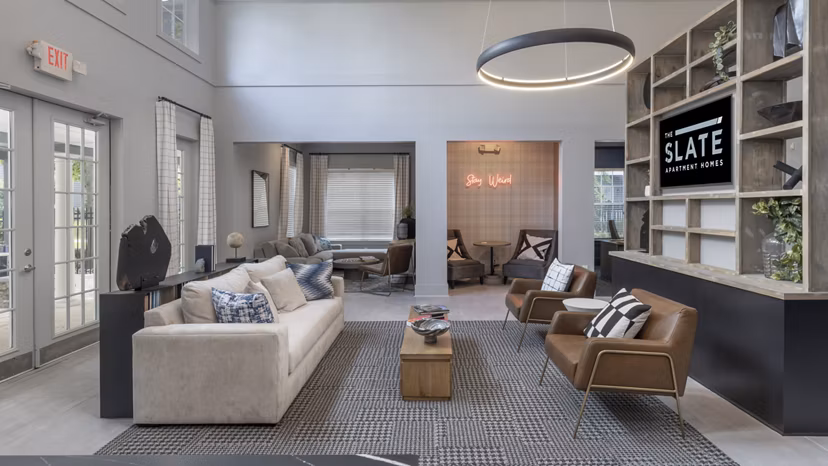 Clubhouse with modern design featuring lounge seating and billiards at The Slate Apartments, a luxury Greystar community