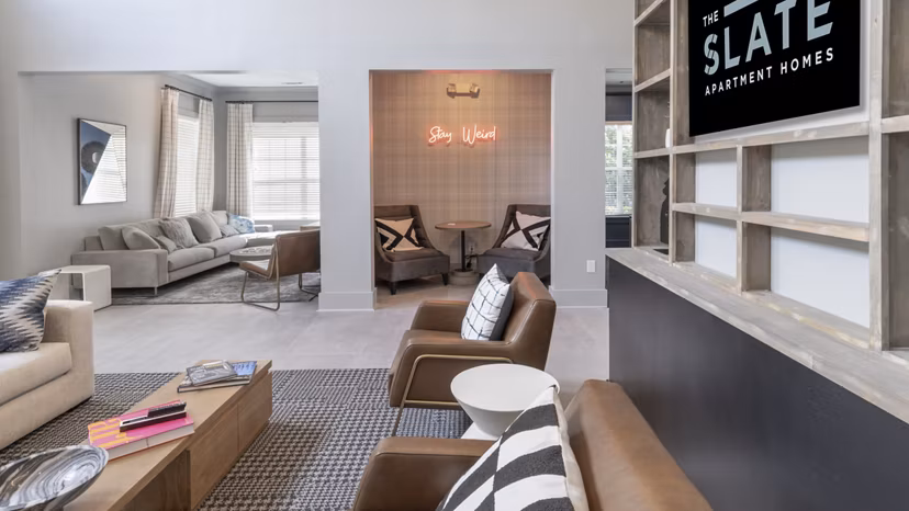 Clubhouse featuring modern lounge seating and large-screen TV at The Slate Apartments in luxury Greystar community