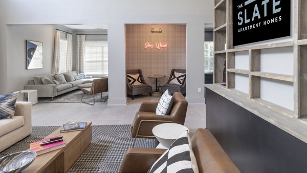 Clubhouse featuring modern lounge seating and large-screen TV at The Slate Apartments in luxury Greystar community