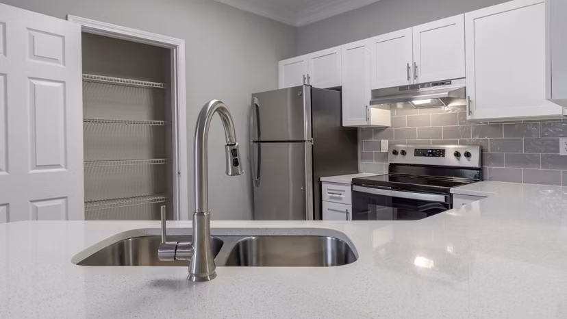 Modern kitchen with stainless steel appliances and granite countertops in The Slate Apartments